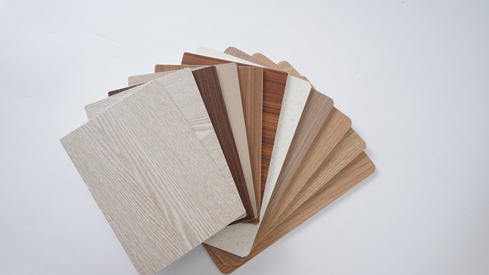 Fan of real ACP color samples — wood-grain and stone finishes, all available across coating systems